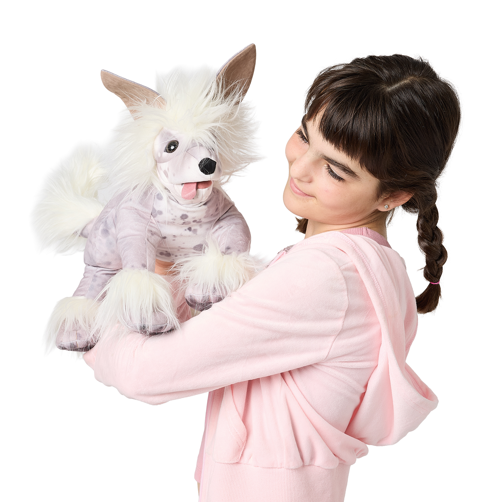Girl holding up a Folkmanis Chinese Crested Dog hand puppet with a white fur crest, spotted body, and tongue sticking out