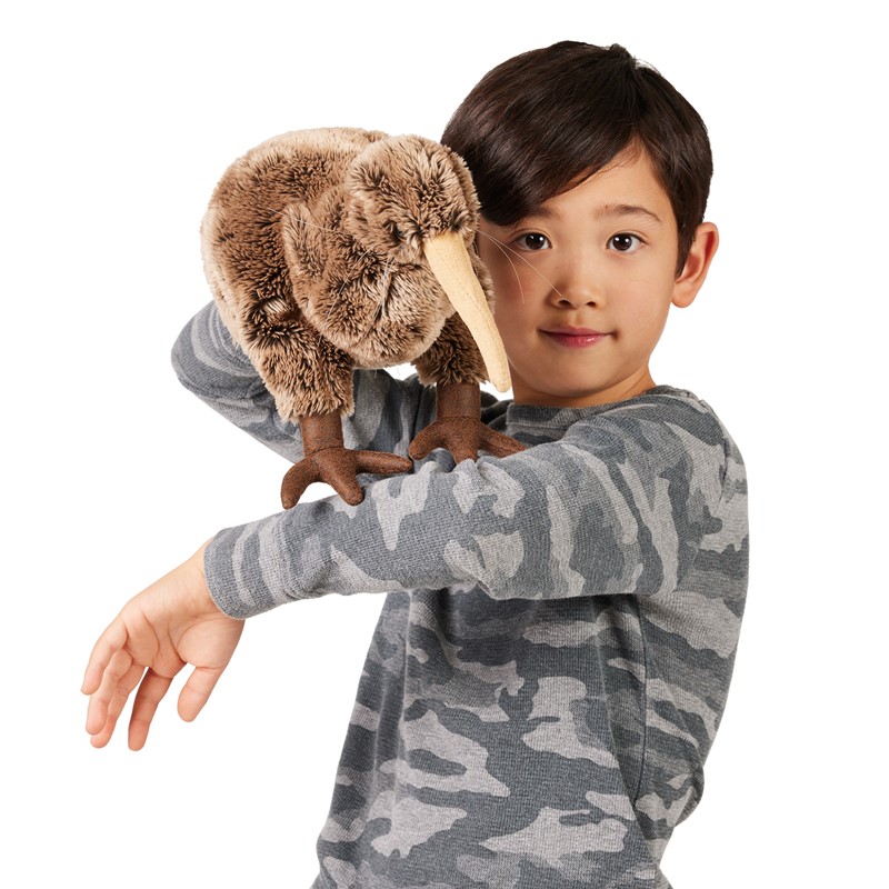 Folkmanis Kiwi-Handpuppe auf dem ausgestreckten Arm eines Jungen, braunes Plüschgefieder und langer beiger Schnabel, Frontalansicht