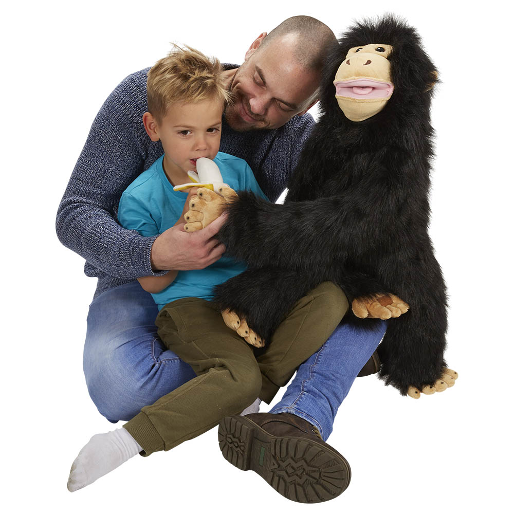 Father and son together holding the The Puppet Company giant chimpanzee hand puppet with a banana, usage example