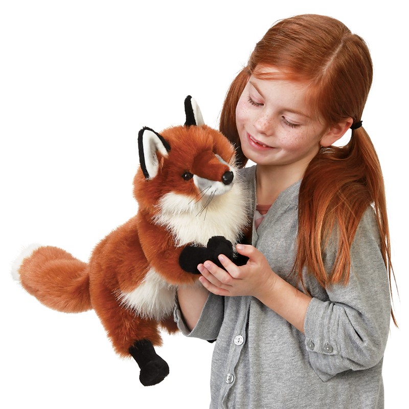 Mädchen hält Folkmanis Handpuppe großer Rotfuchs mit rotem Fell, weißer Brust und schwarzen Pfoten in den Händen