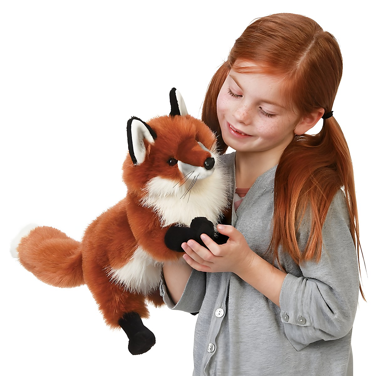 Girl holding the Folkmanis large red fox hand puppet with red fur, white chest and black paws