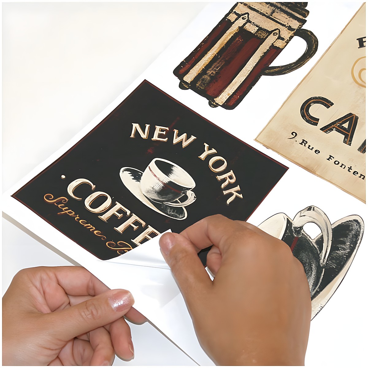 RoomMates wall decal Coffee House Peel & Stick, hands peeling a New York Coffee sign motif off the backing sheet, usage example