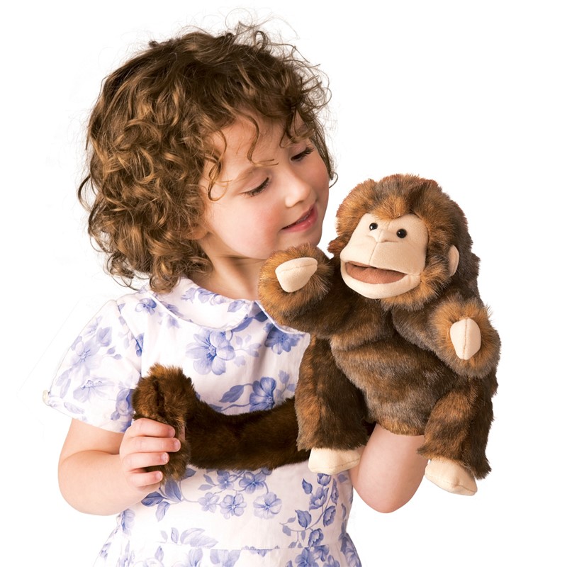 Girl wearing a brown Folkmanis monkey hand puppet with a movable mouth on her hand