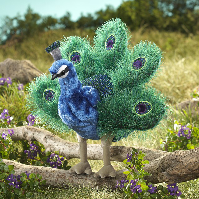 Folkmanis Handpuppe kleiner Pfau mit aufgefächertem grün-blauem Rad und lila Augenflecken, stehend auf einem Ast