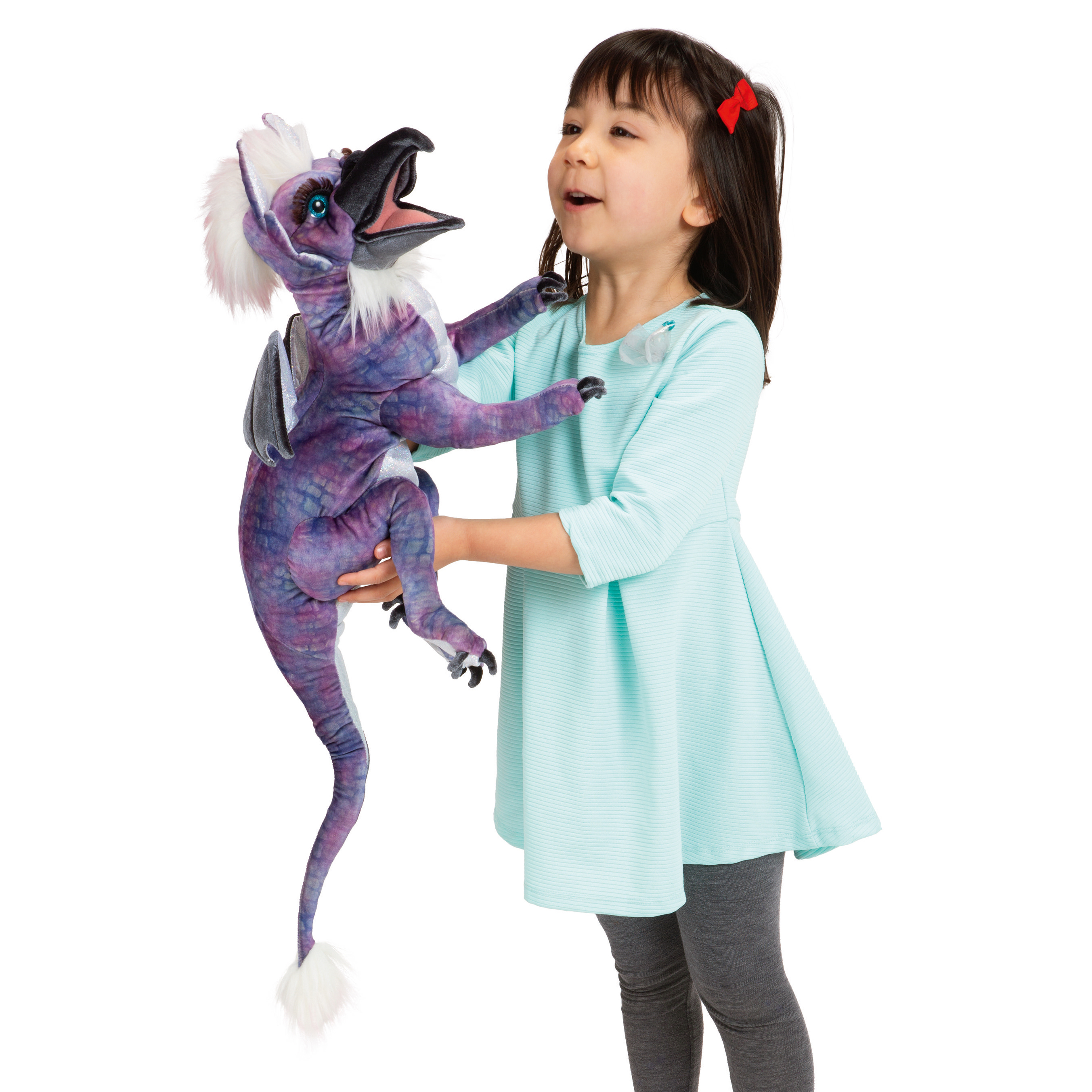 Girl operating the Folkmanis beaked dragon hand puppet with purple scale pattern, white fur trim and movable mouth against a white background