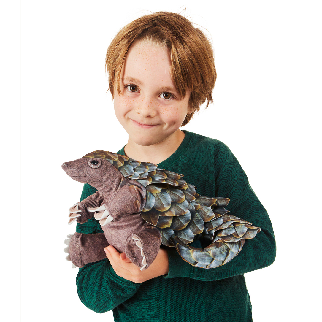 Junge hält Folkmanis Pangolin-Handpuppe mit detaillierten blau-braunen Schuppen und beweglichem Maul vor weißem Hintergrund.