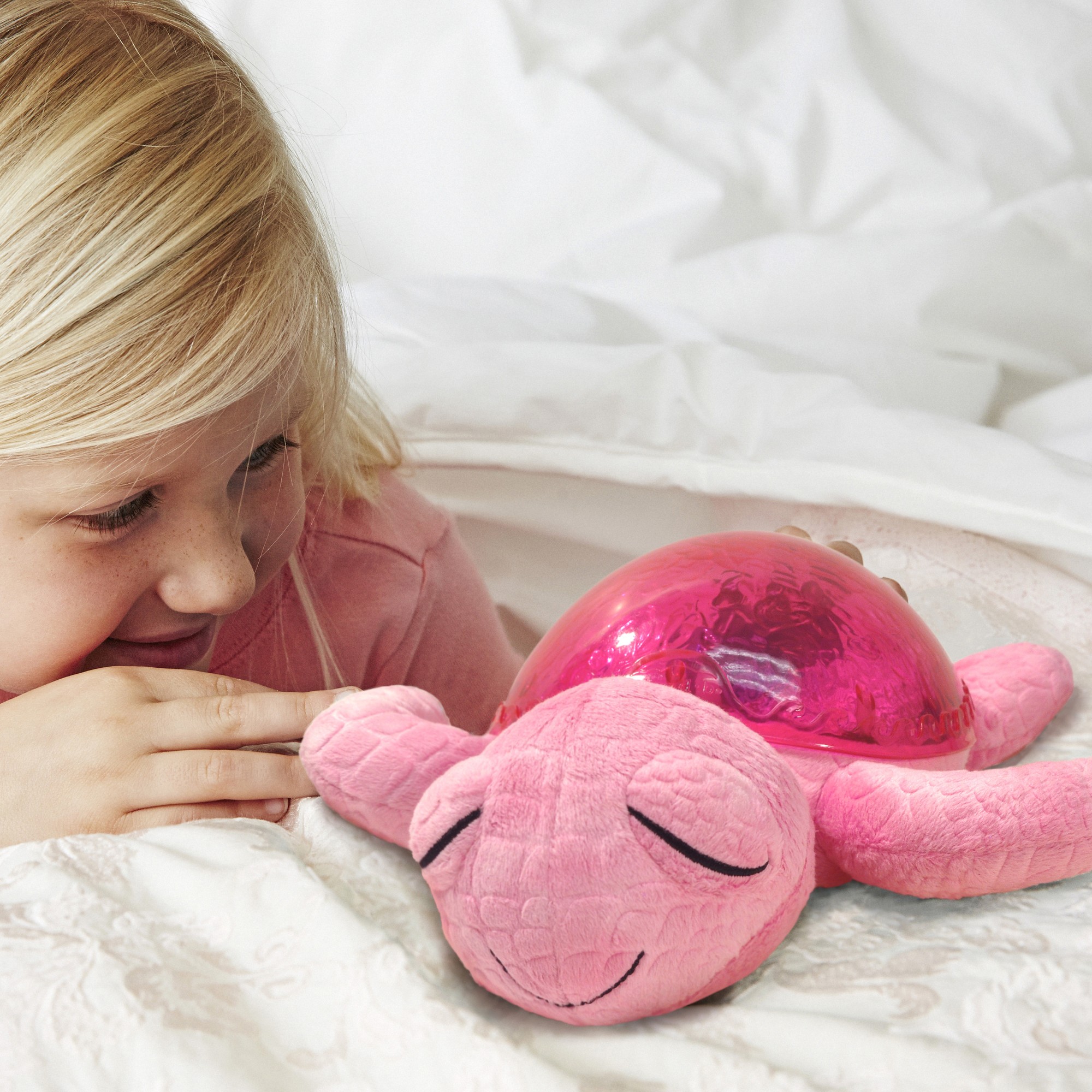 Cloud b Einschlafhilfe Tranquil Turtle Pink, Anwendungsfoto mit Mädchen und pinkem Kuscheltier im Bett