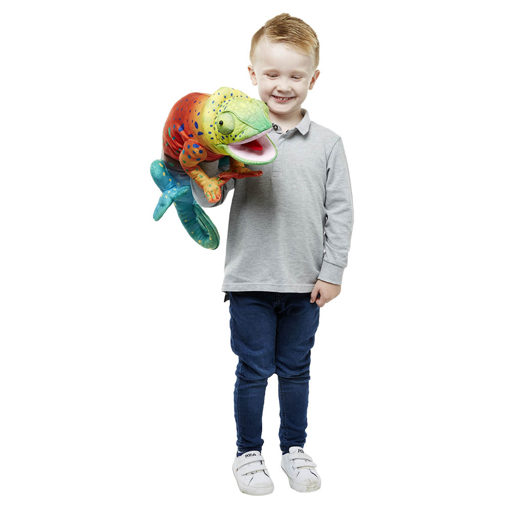 Lächelnder Junge trägt die The Puppet Company Handpuppe Großes Chamäleon vor der Brust, Anwendungsbeispiel