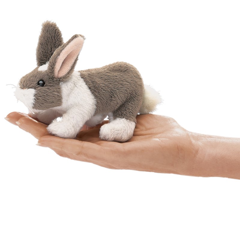 Folkmanis Fingerpuppe mini Kaninchen in Grau-Weiß liegt auf einer geöffneten Handfläche, Seitenansicht