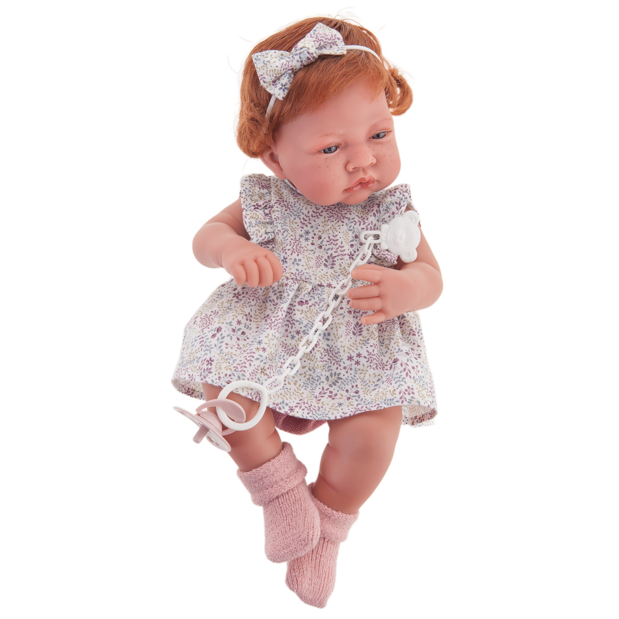 Antonio Juan baby doll New Born, realistic doll with red hair, floral dress, hair bow and pacifier clip, front view
