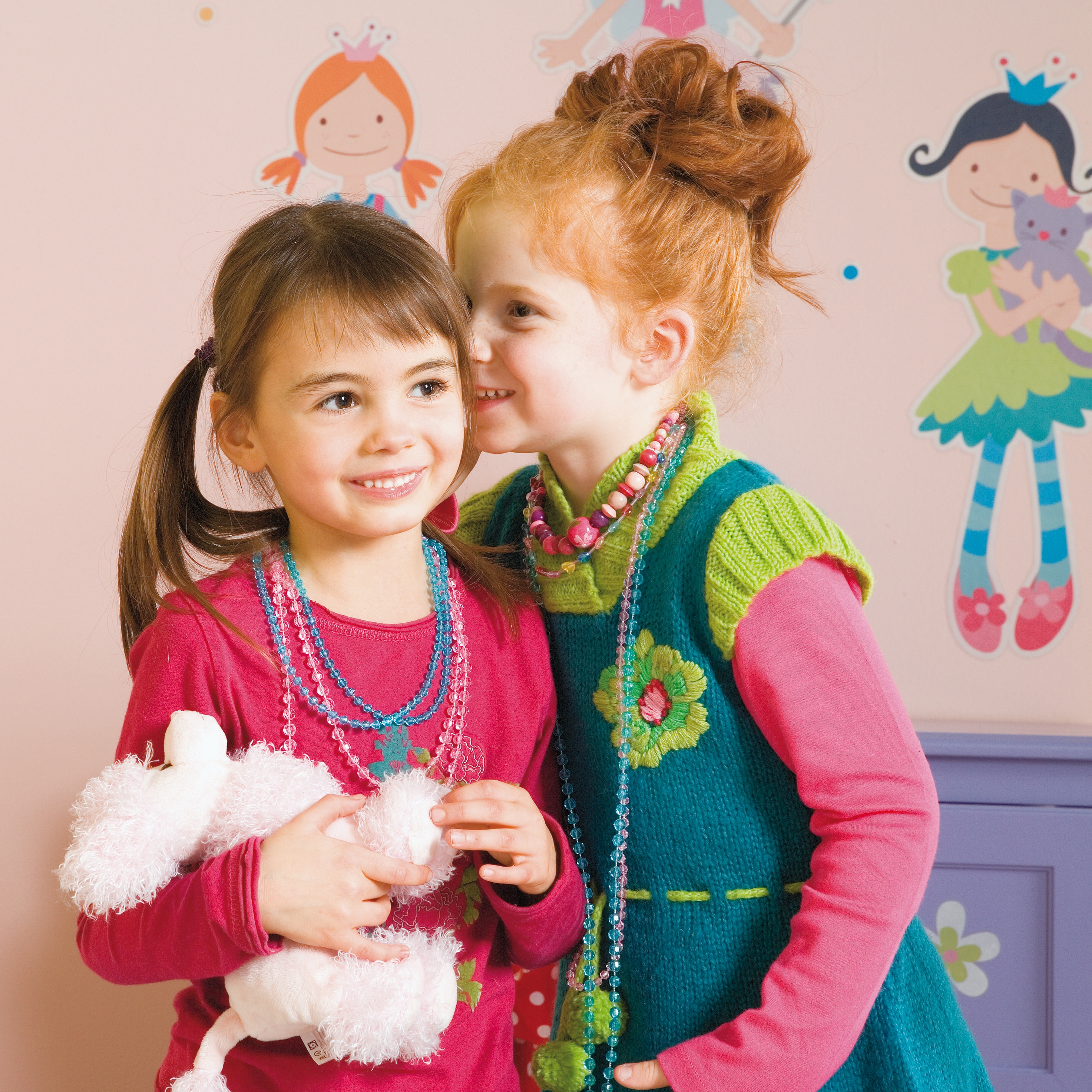 decofun Wanddekoration Zi Za Zou an rosa Kinderzimmerwand, zwei Mädchen davor, Prinzessin und Fee mit lila Haar an der Wand