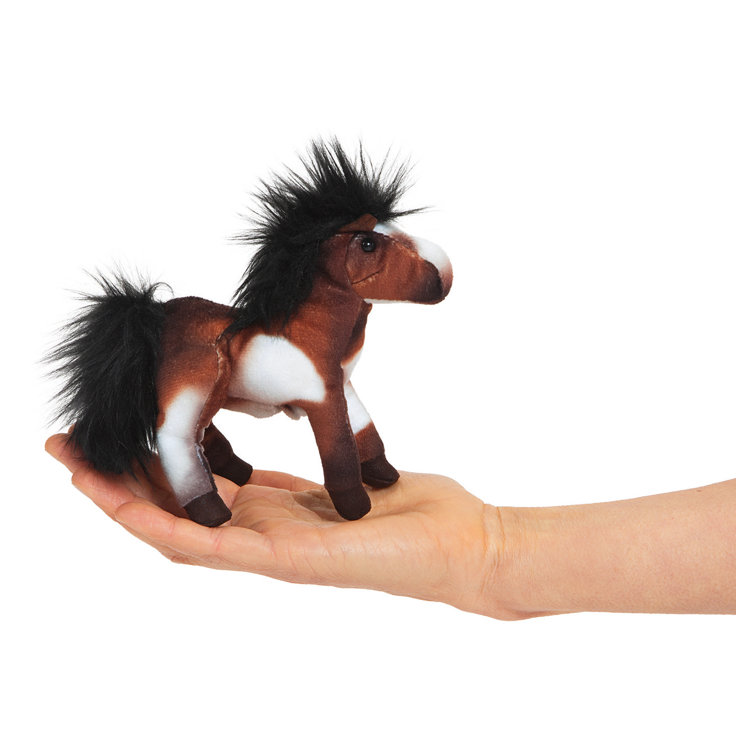Folkmanis mini finger puppet horse in brown and white with a black mane, lying on a palm