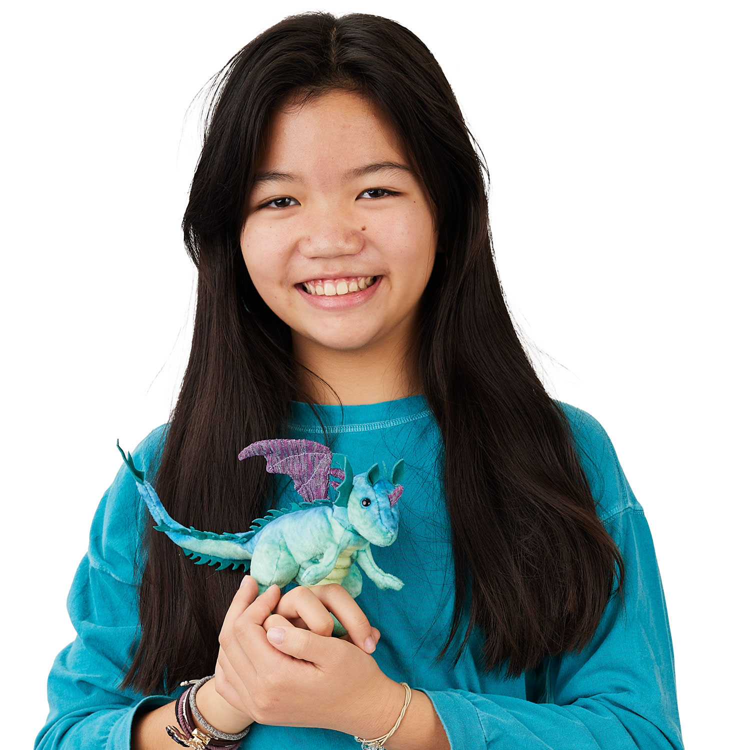 Girl holding a Folkmanis mini dragon finger puppet in mint green with purple wings in both hands against a white background