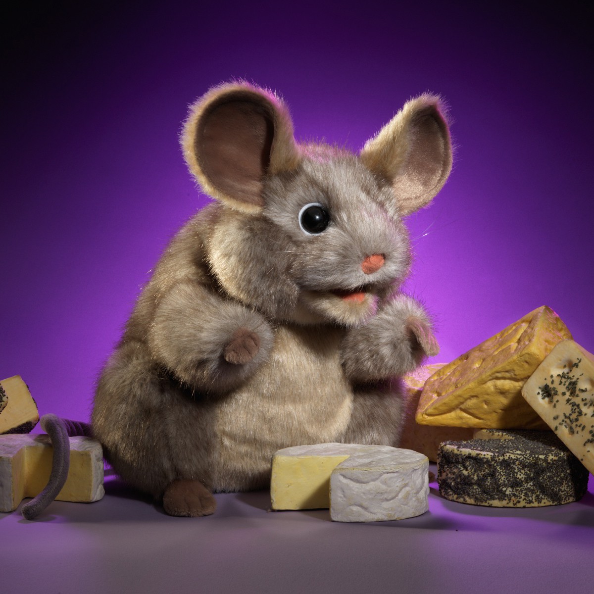 Folkmanis grey mouse hand puppet with large ears, set against a purple background and surrounded by various types of cheese