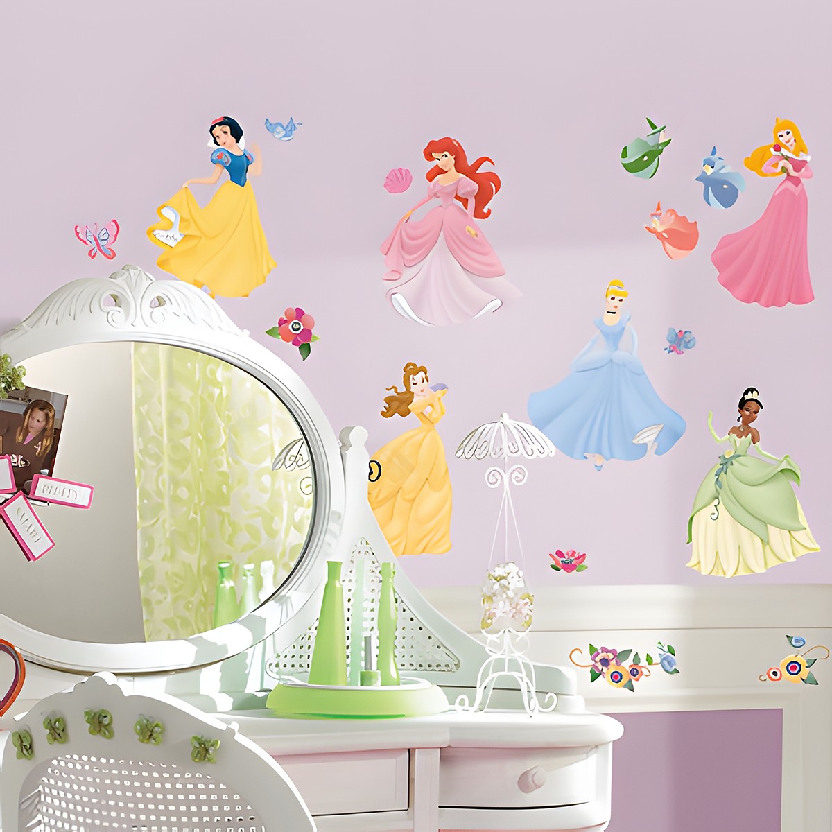 RoomMates wall decal Disney Princess, motifs with Snow White, Ariel, Aurora, Belle, Cinderella and Tiana on a purple children's room wall above a dressing table