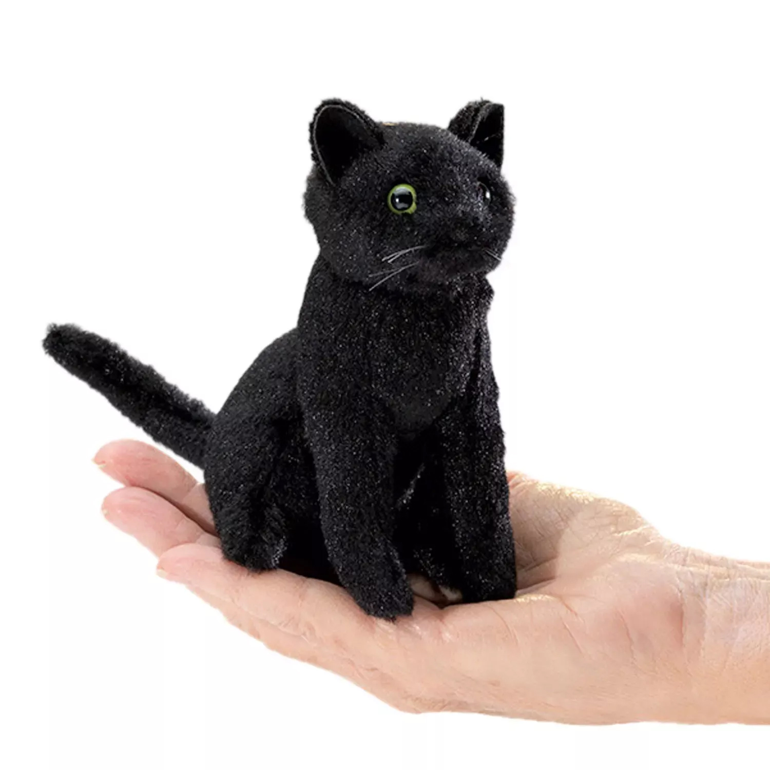 Folkmanis mini black cat finger puppet with green eyes, sitting on a palm for size comparison