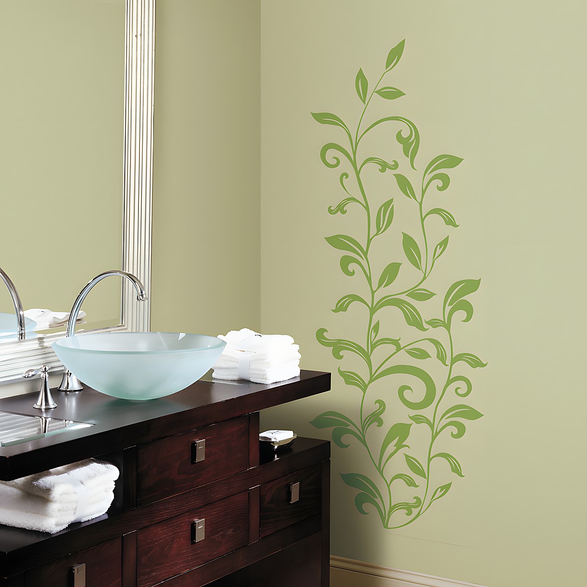 RoomMates wall decal Leaf Scroll Peel & Stick, green leaf vine motif on an olive green bathroom wall above a vanity unit