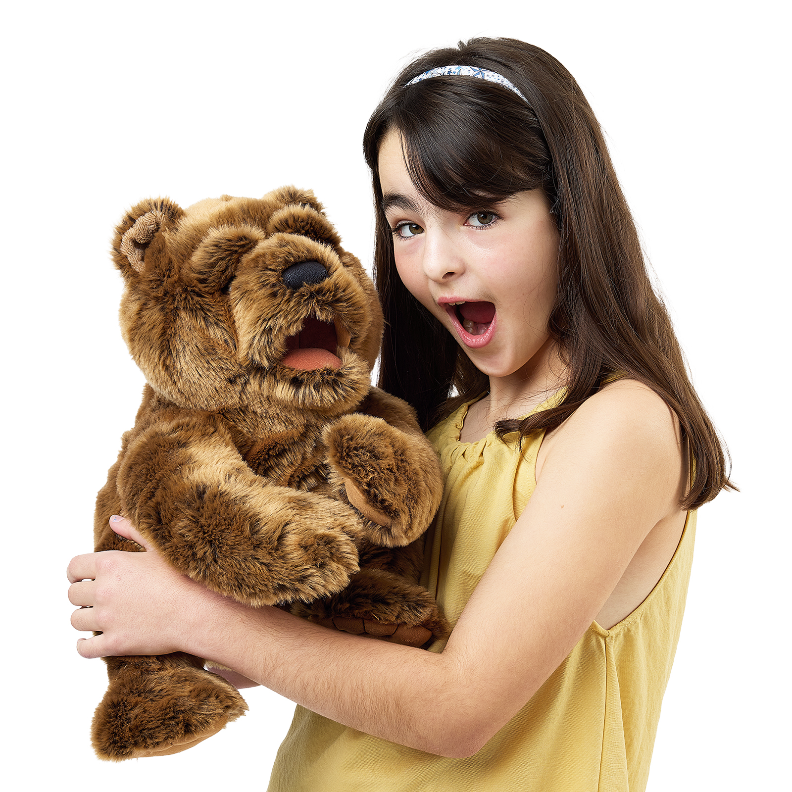 Folkmanis Handpuppe großer Bär nah am Gesicht eines Mädchens, Kopf leicht seitlich mit geschlossenem Maul.