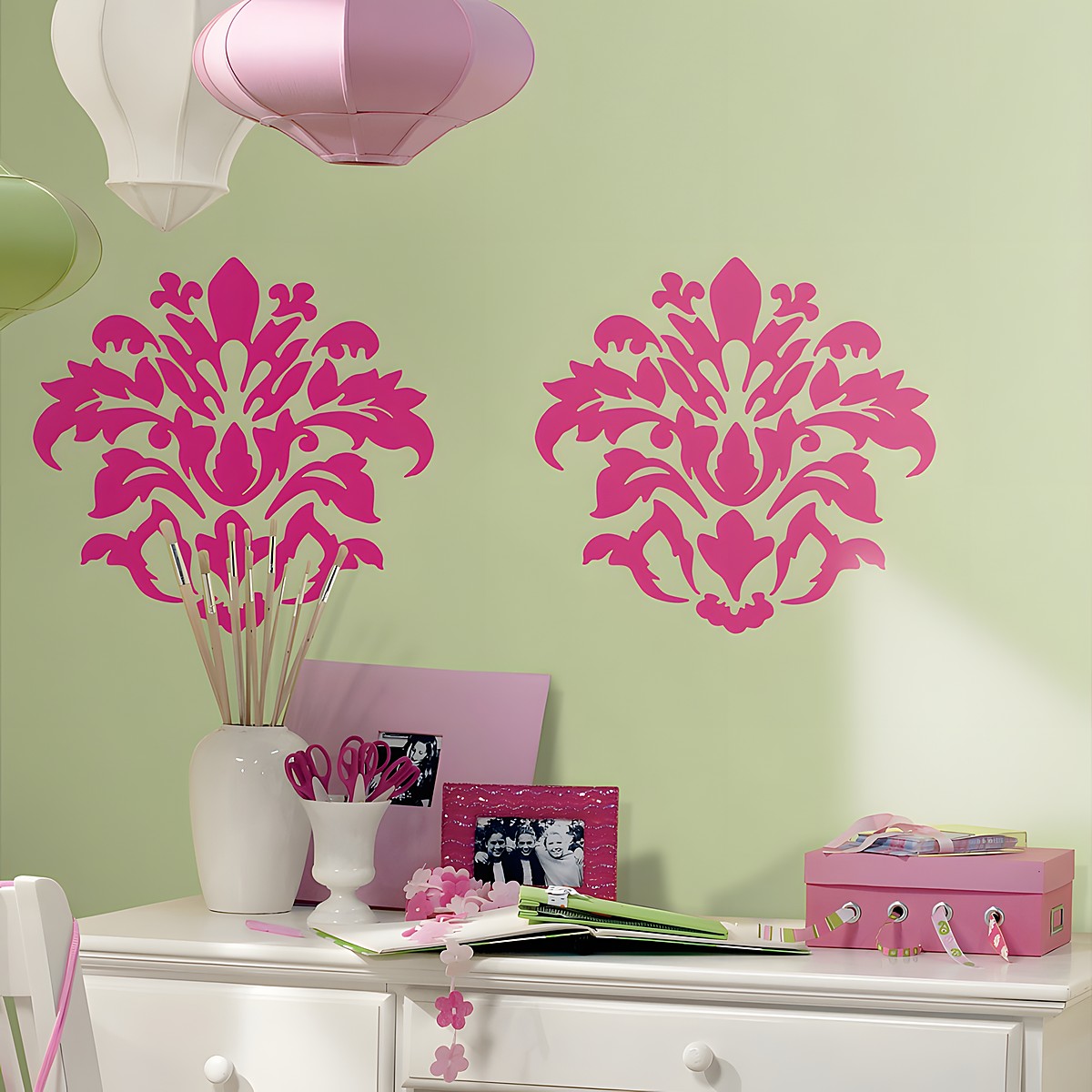 RoomMates wall decal Damask Pink, two pink damask ornaments on a green wall behind a white chest of drawers