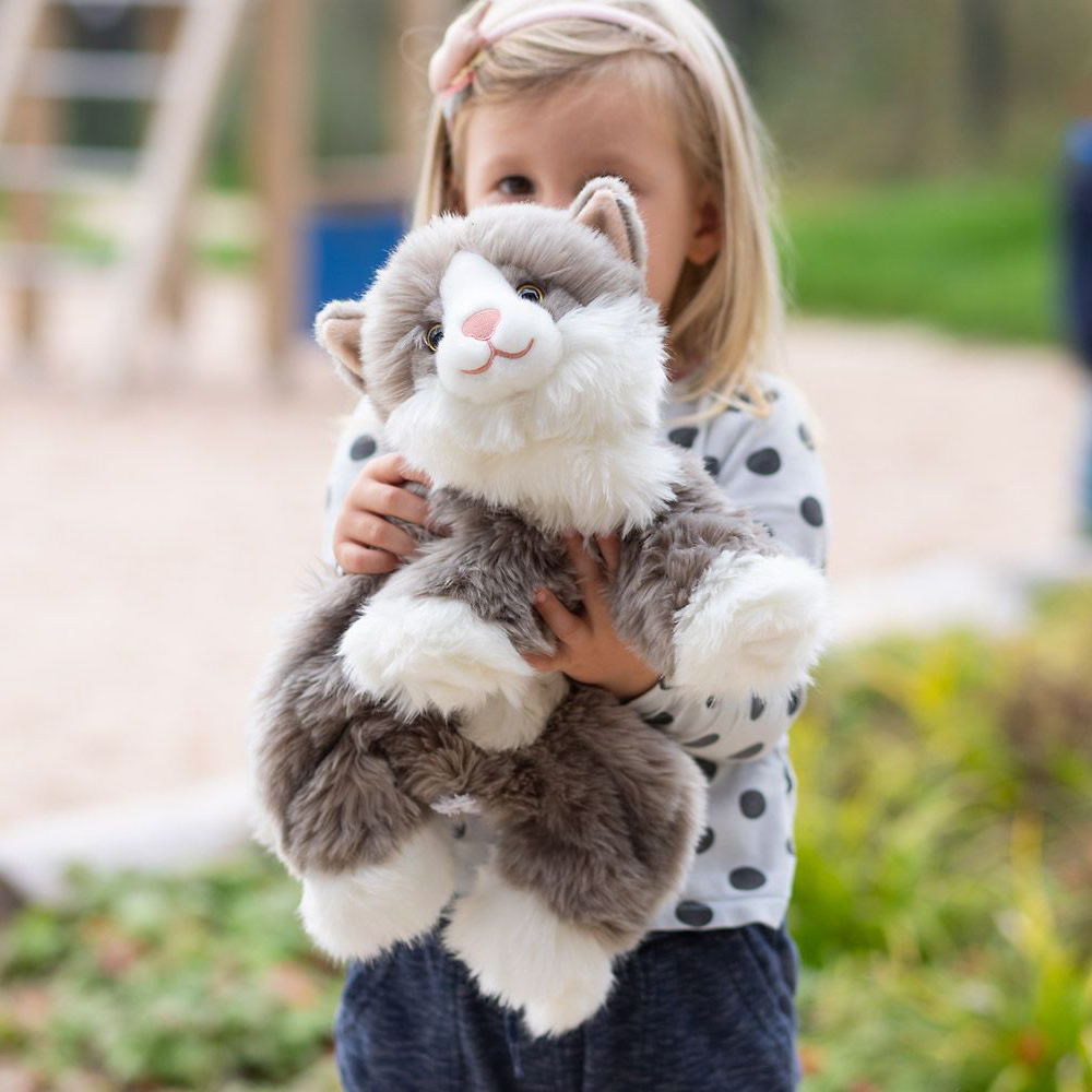 Kind umarmt die Joyk Empathiepuppe Billy, grau-weiße Katze mit flauschigem Fell