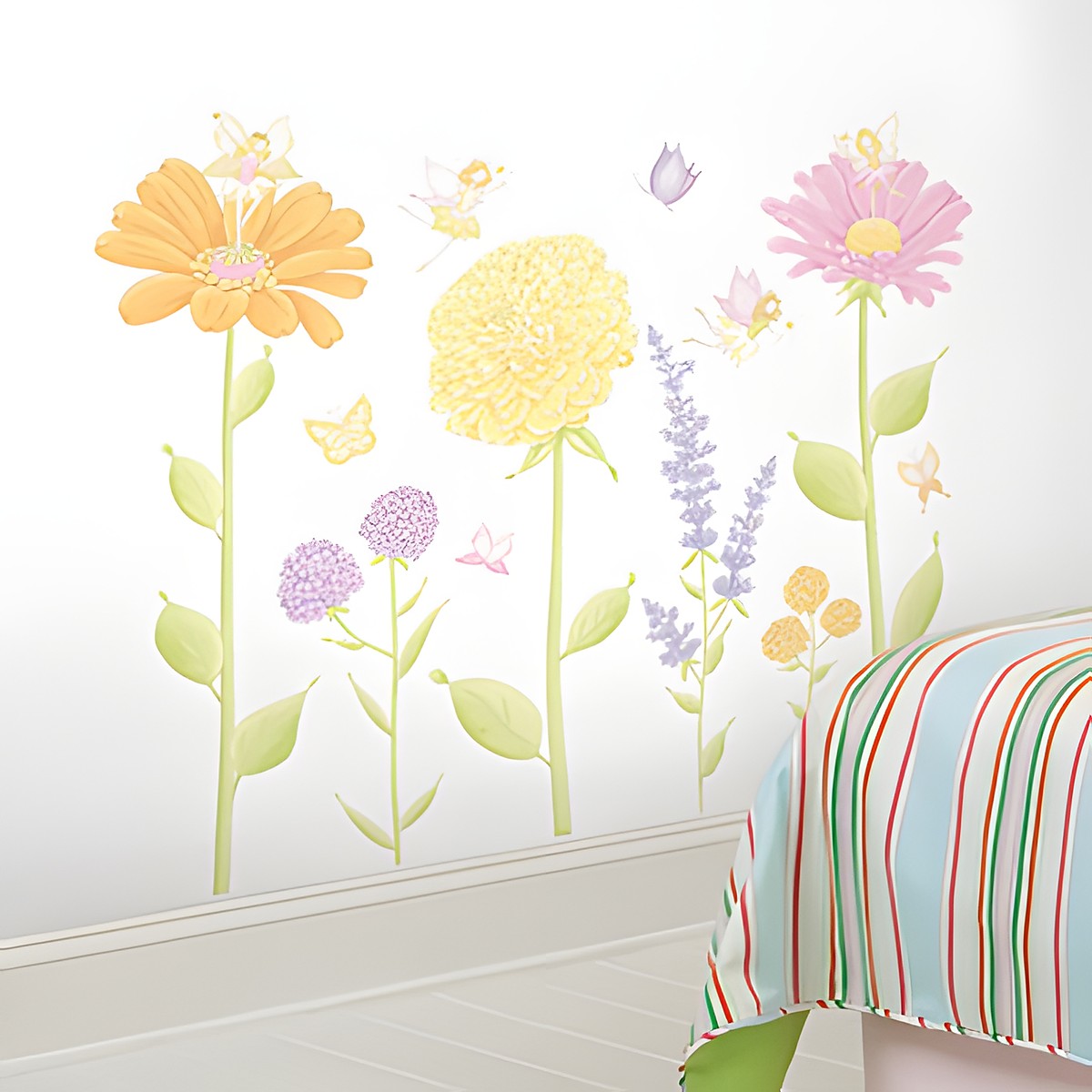 RoomMates Wandbild Fairy Garden, bunte Blumenmotive mit kleinen Feen und Schmetterlingen an einer weißen Kinderzimmerwand neben einem gestreiften Bett