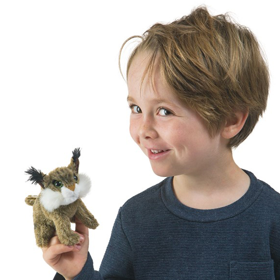 Lächelndes Kind hält kleine Folkmanis Fingerpuppe Mini-Luchs mit Pinselohren und weißem Bartbereich auf dem Zeigefinger.