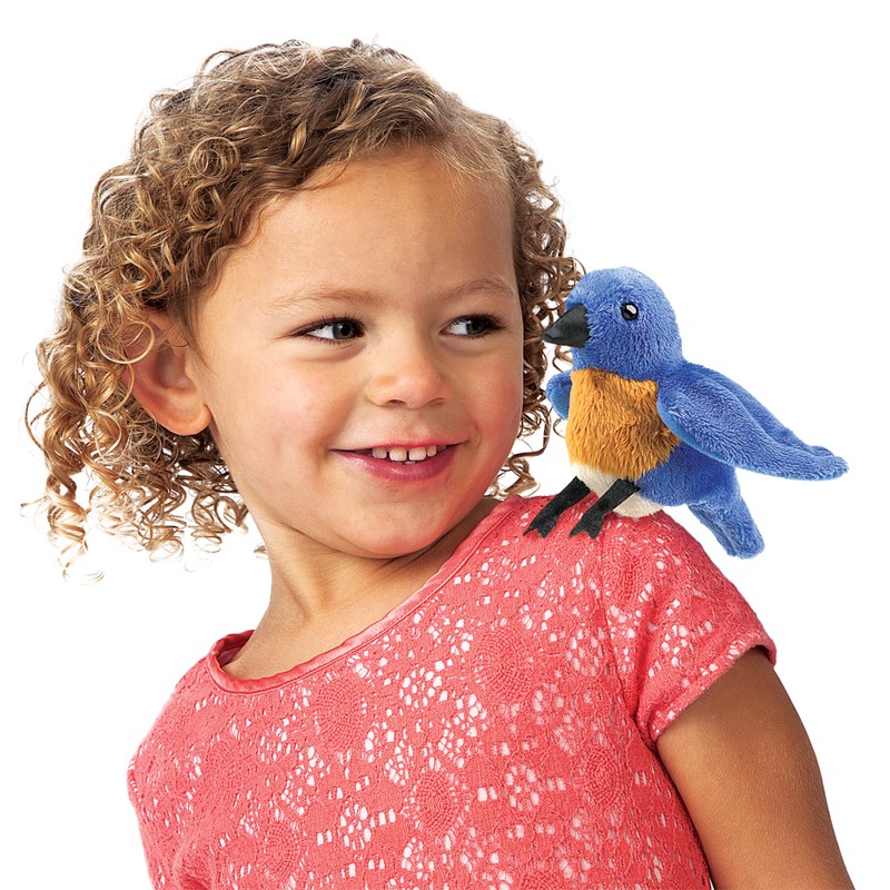 Folkmanis Fingerpuppe mini Hüttensänger-Vogel in Blau-Orange auf der Schulter eines lächelnden Mädchens