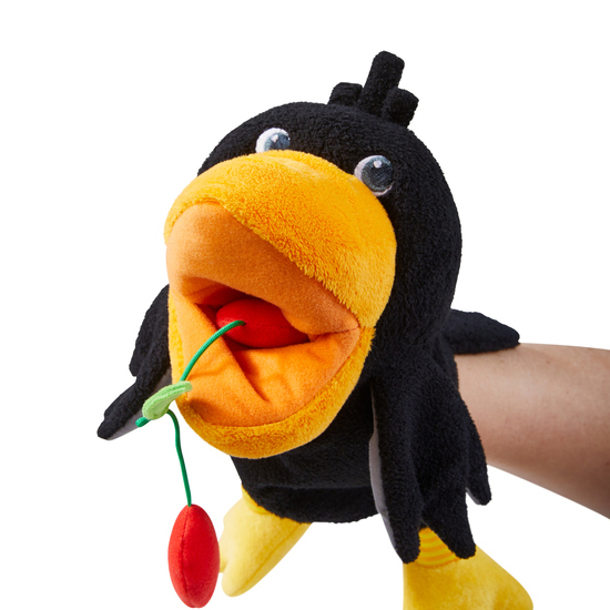 HABA baby hand puppet raven Theo, worn on an arm holding a cherry stem in its open beak