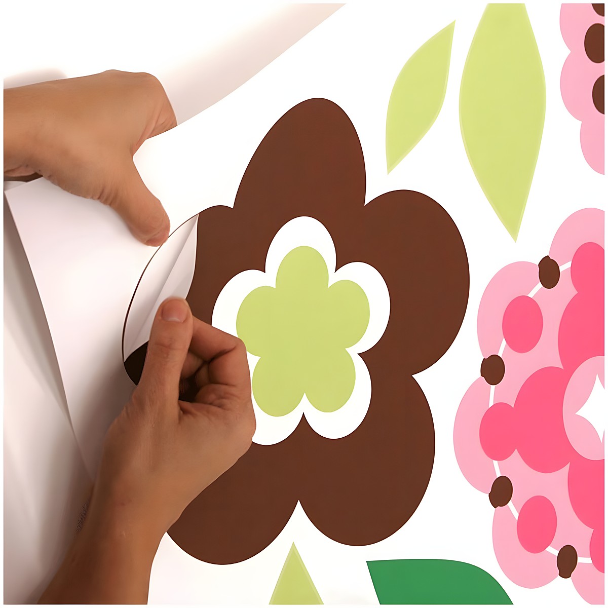 RoomMates Wandbild Growing Flowers, Hände lösen ein braun-grünes Blütenmotiv vom Trägerbogen, Anwendungsbeispiel