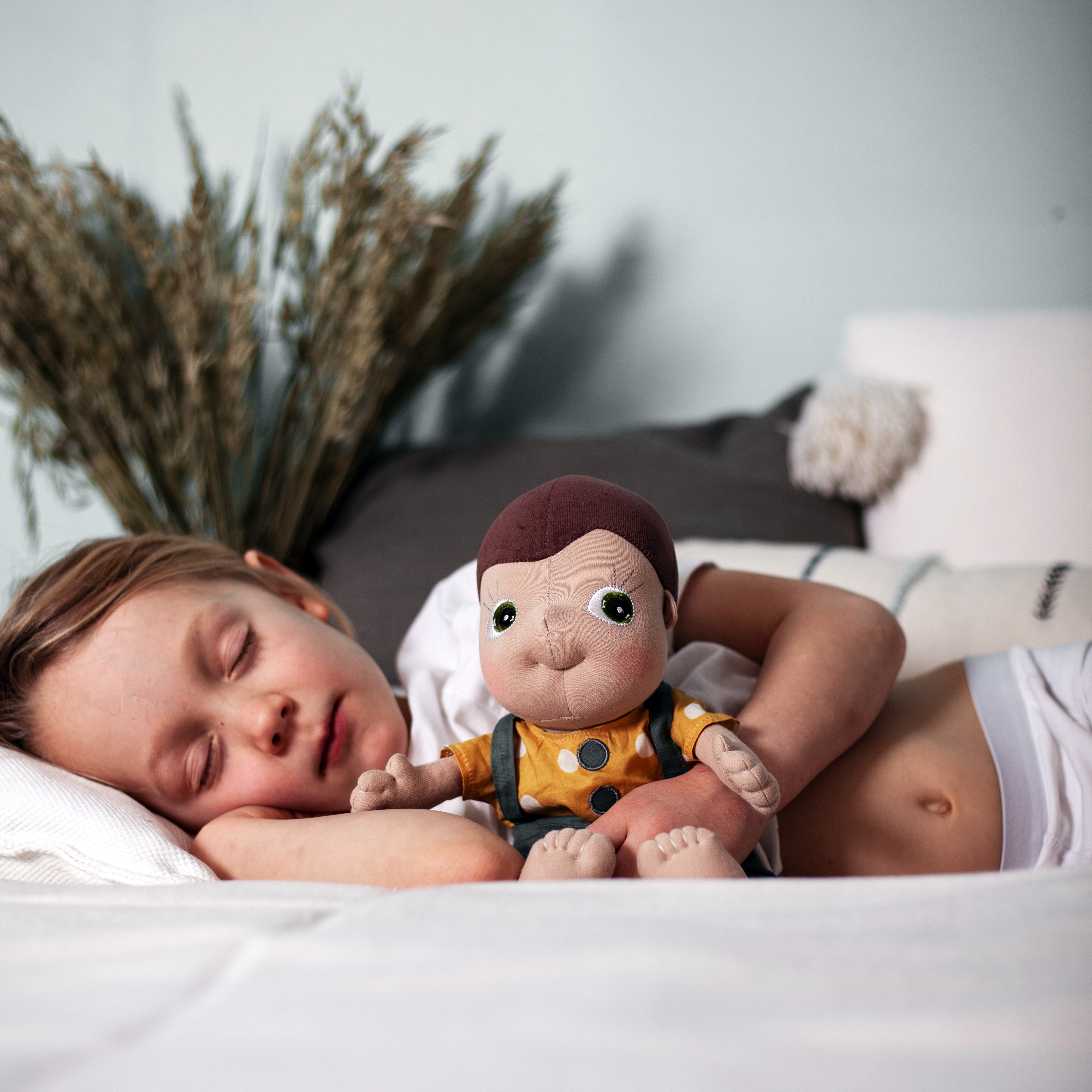 Sleeping child cuddling with the Rubens Tummies doll Fahren