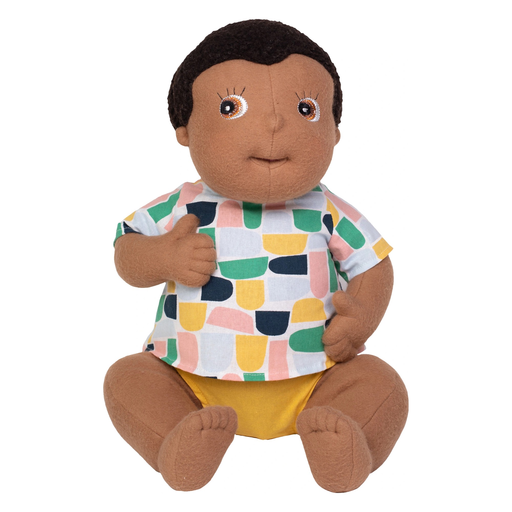 Rubens Barn baby doll Ali with dark hair, colourful patterned shirt and yellow nappy pants, sitting