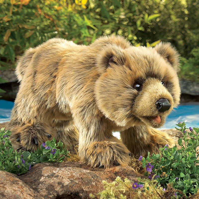 Folkmanis Handpuppe Grizzlybär mit sandbraunem Fell in kriechender Pose auf Felsen, Seitenansicht