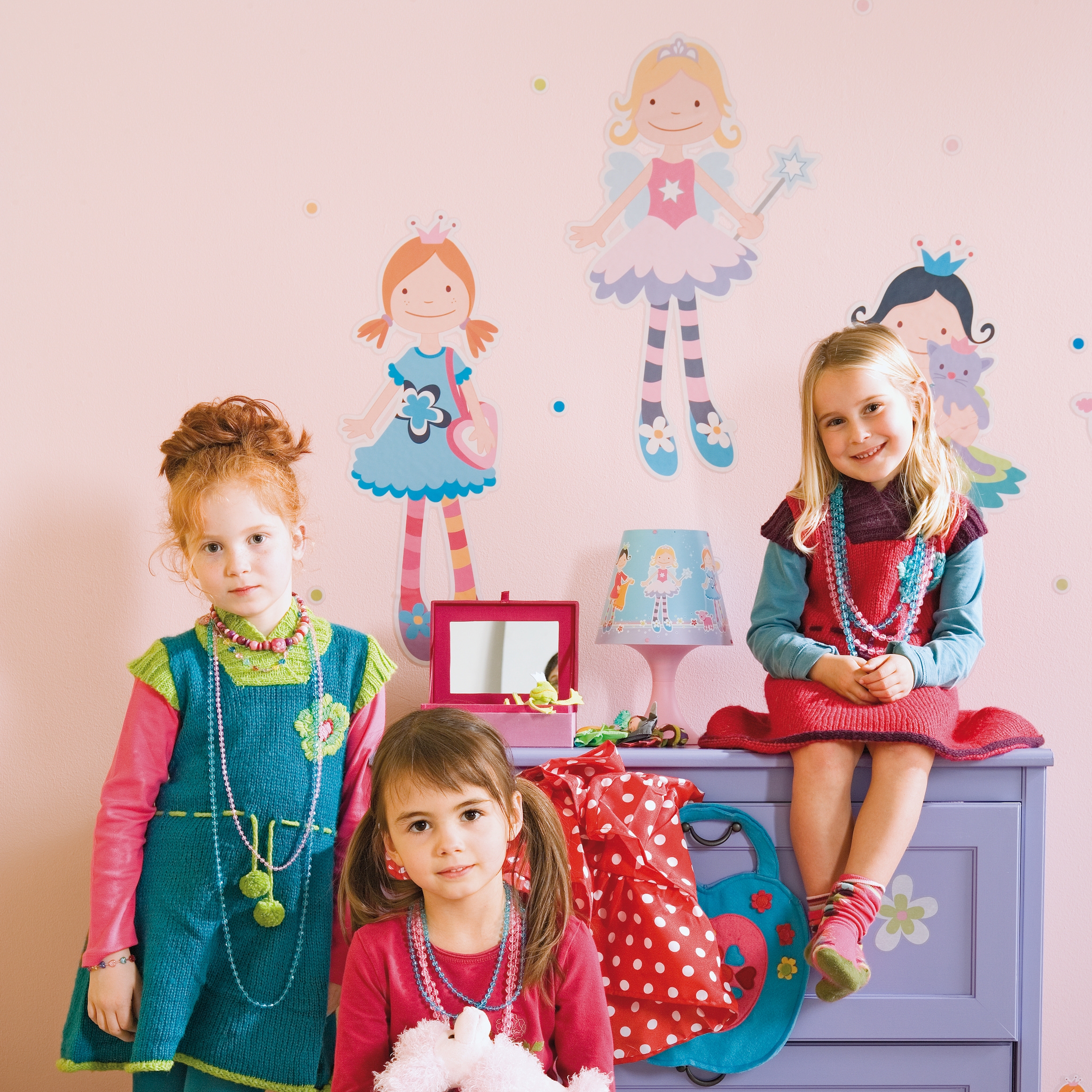 decofun Wanddekoration Zi Za Zou an rosa Kinderzimmerwand, Feenfiguren über einer lila Kommode