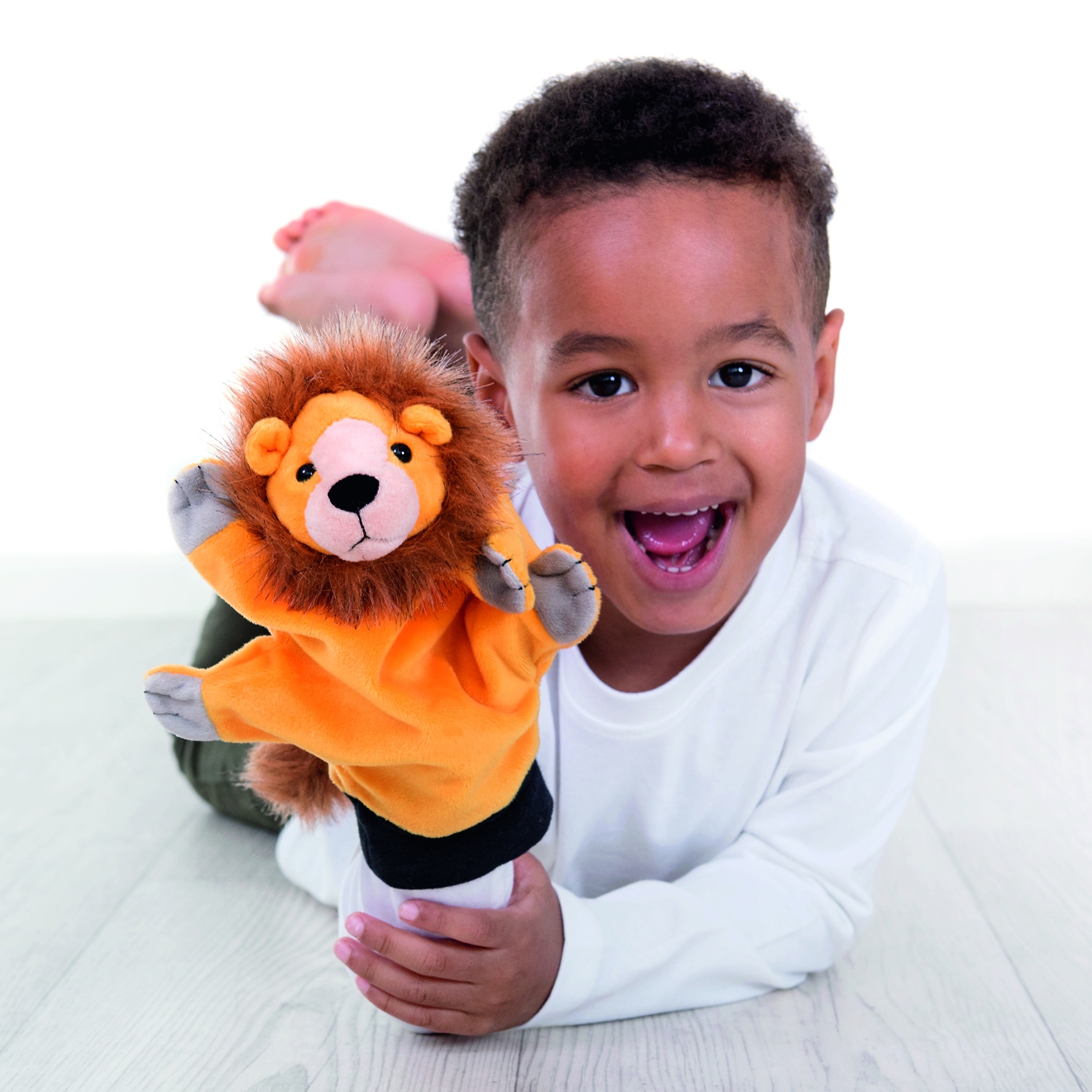 Junge lacht mit der Beleduc Handpuppe Löwe auf der Hand, Anwendungsbeispiel