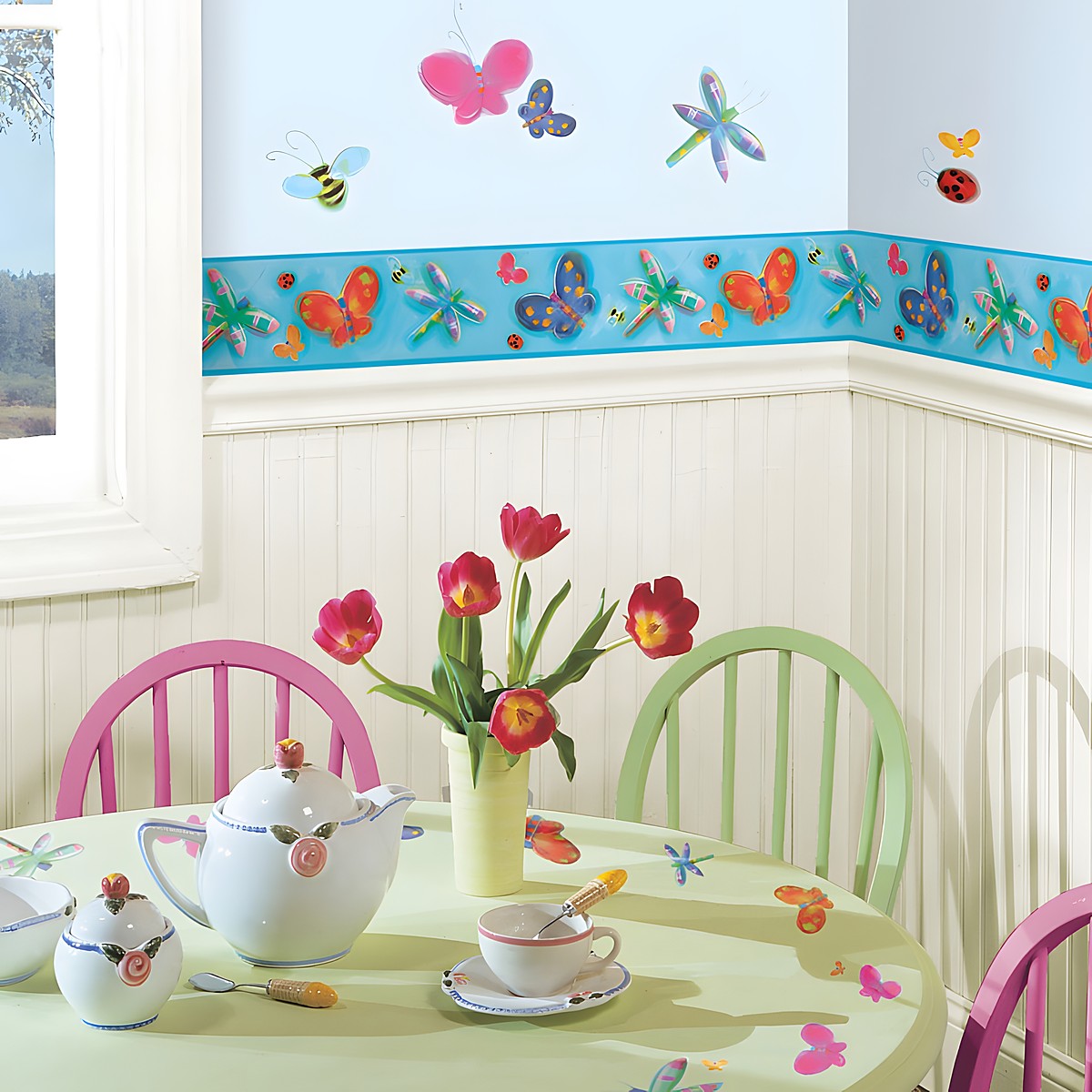 RoomMates border Jelly Bugs, jelly-shimmer border strip with butterflies and dragonflies above colourful insect wall decals on a pink kitchen wall