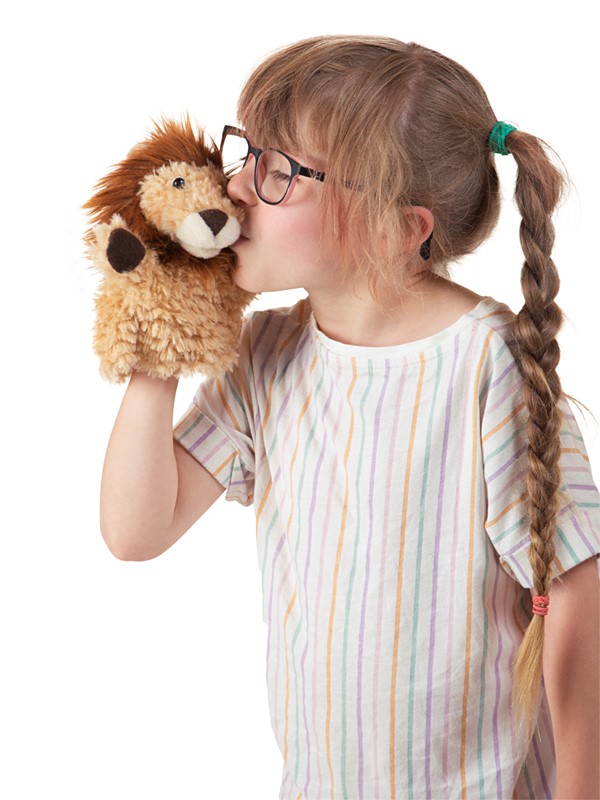 Mädchen mit Zöpfen küsst eine Folkmanis Handpuppe kleiner Löwe mit hellbraunem Plüschfell und dunkler Mähne