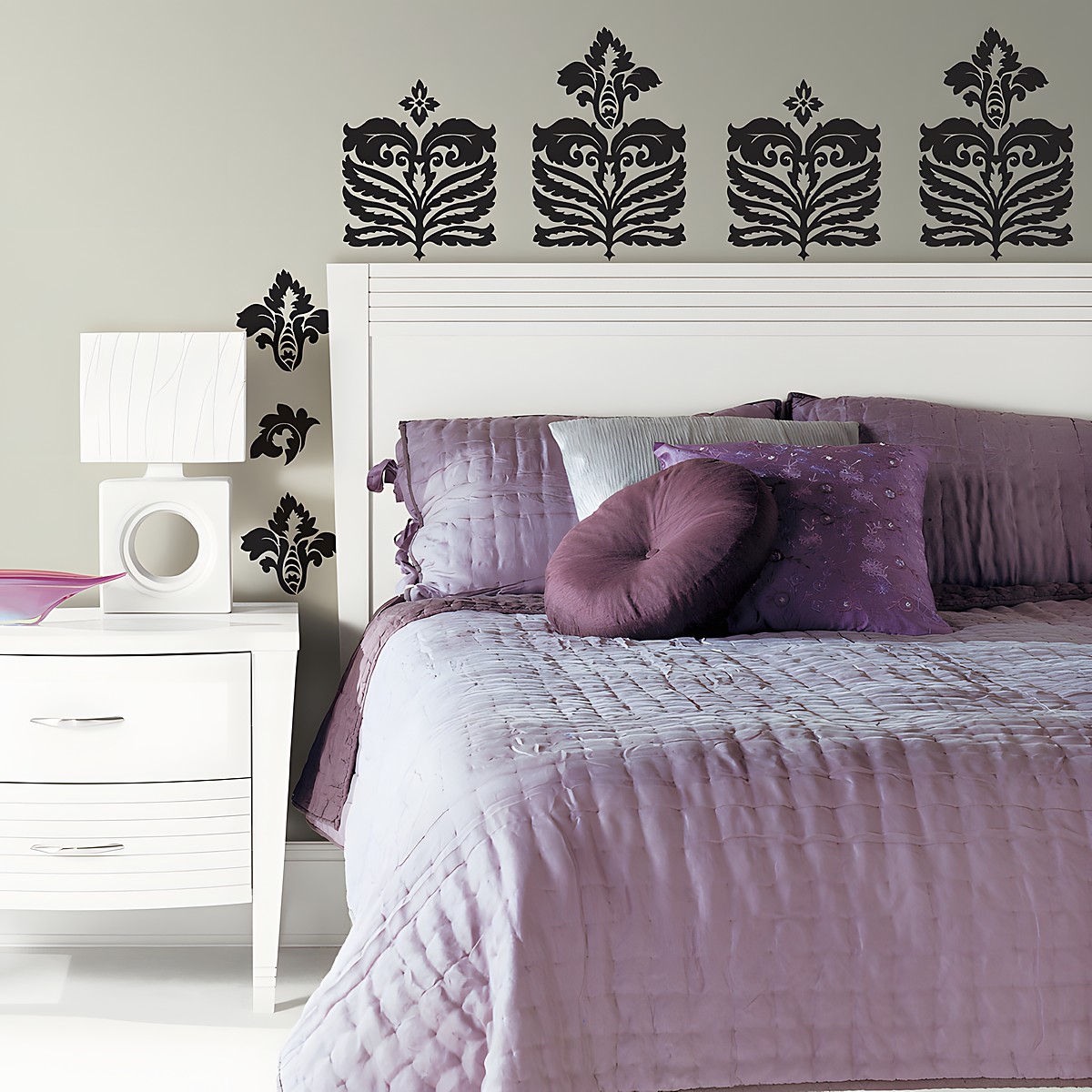 RoomMates wall decal Class A Peel & Stick, several black damask ornaments arranged in a row above a bed with purple bedding