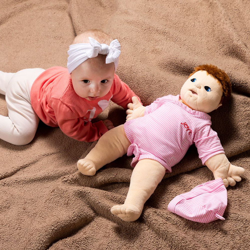 Baby neben der gleich großen Joyk Empathiepuppe Baby Lilly auf einer Kuscheldecke