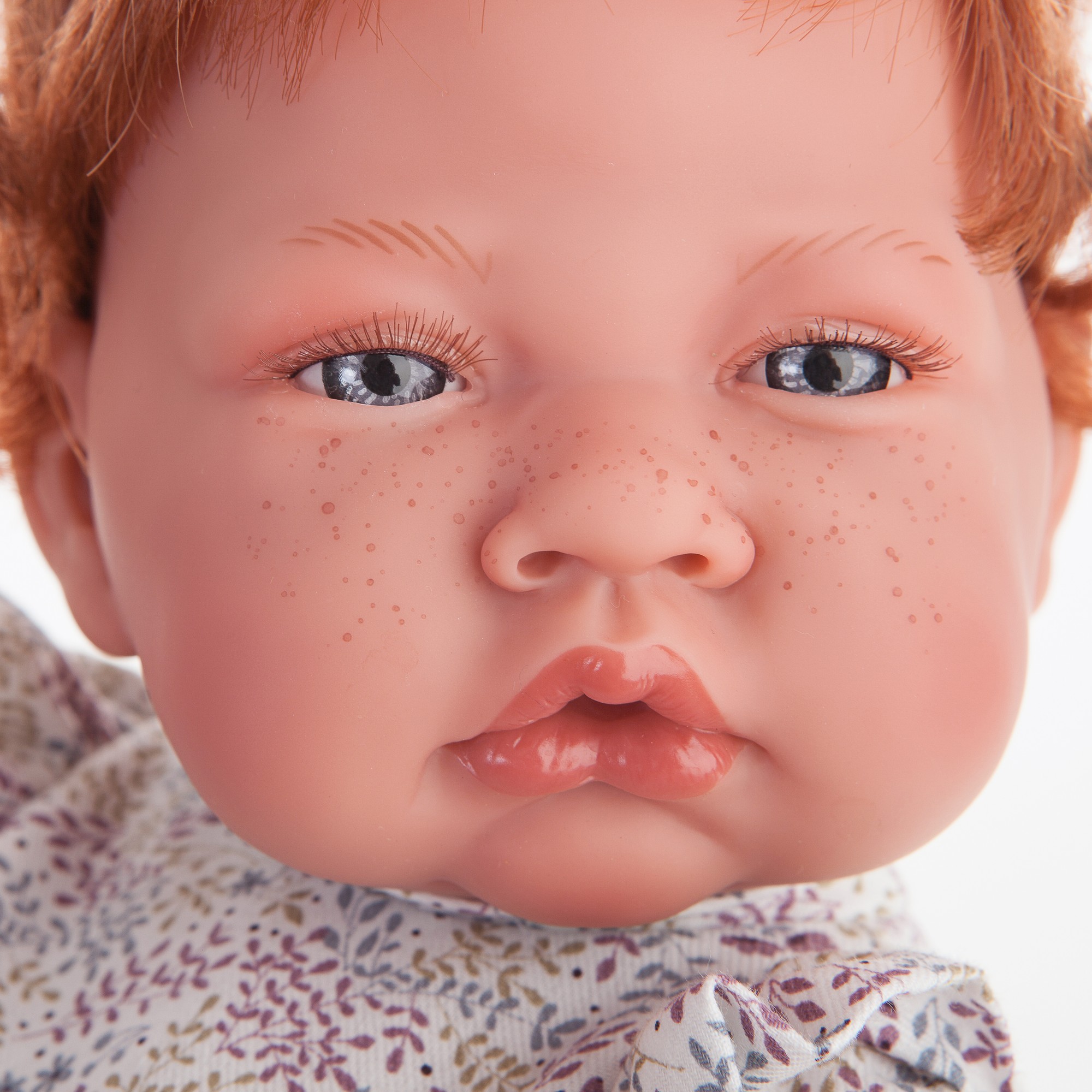 Antonio Juan baby doll New Born, close-up of the face with red hair, freckles and floral dress collar