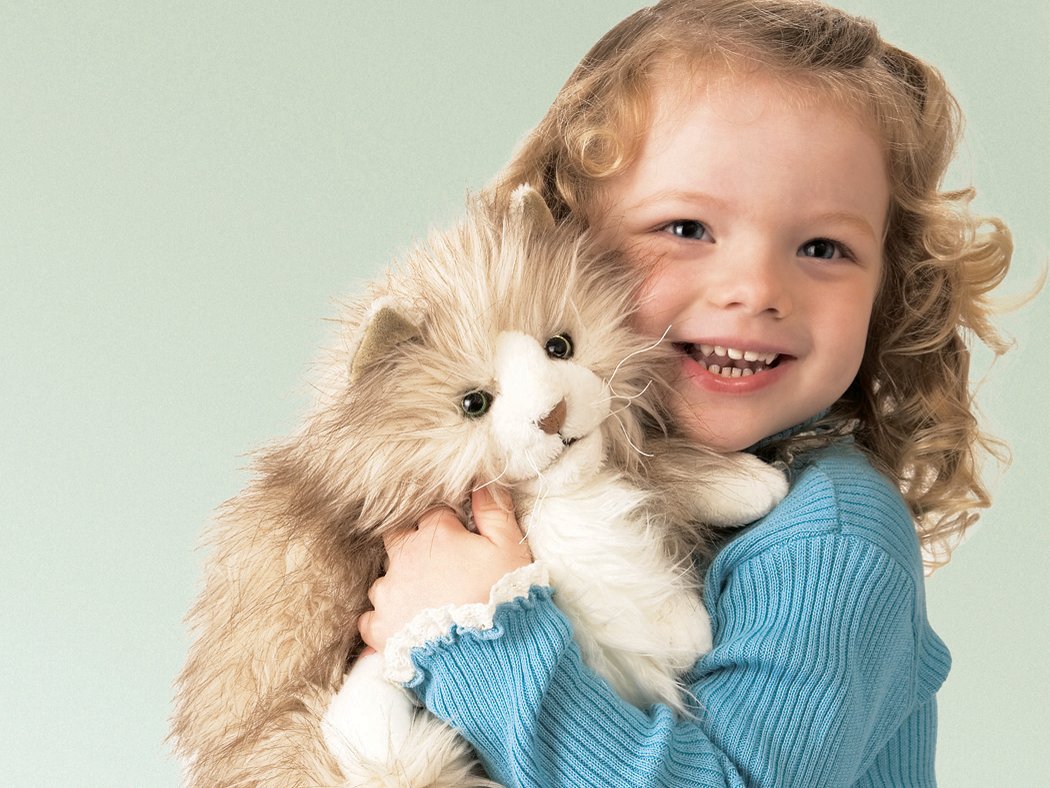 Mädchen umarmt die Folkmanis Handpuppe flauschige Katze