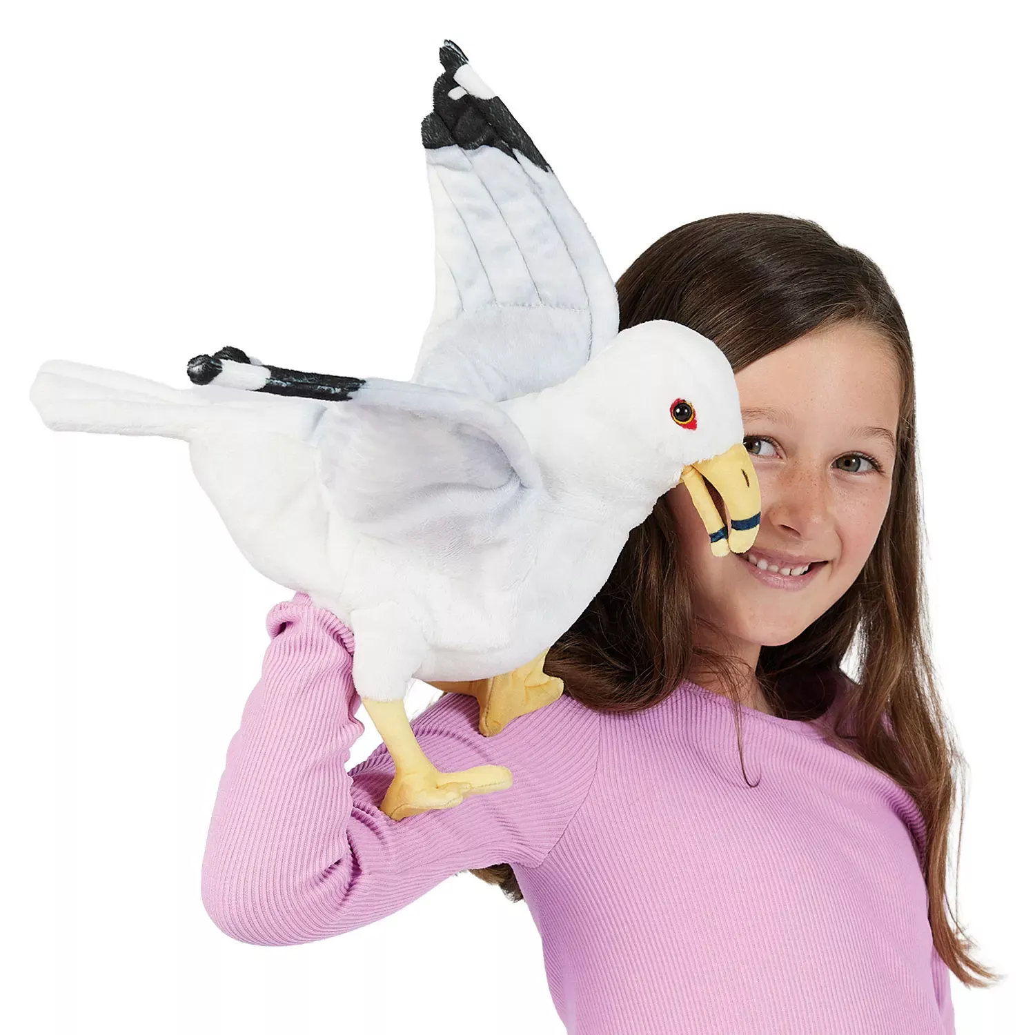 Girl holding a Folkmanis seagull hand puppet with spread wings, white plumage and a yellow beak on her arm