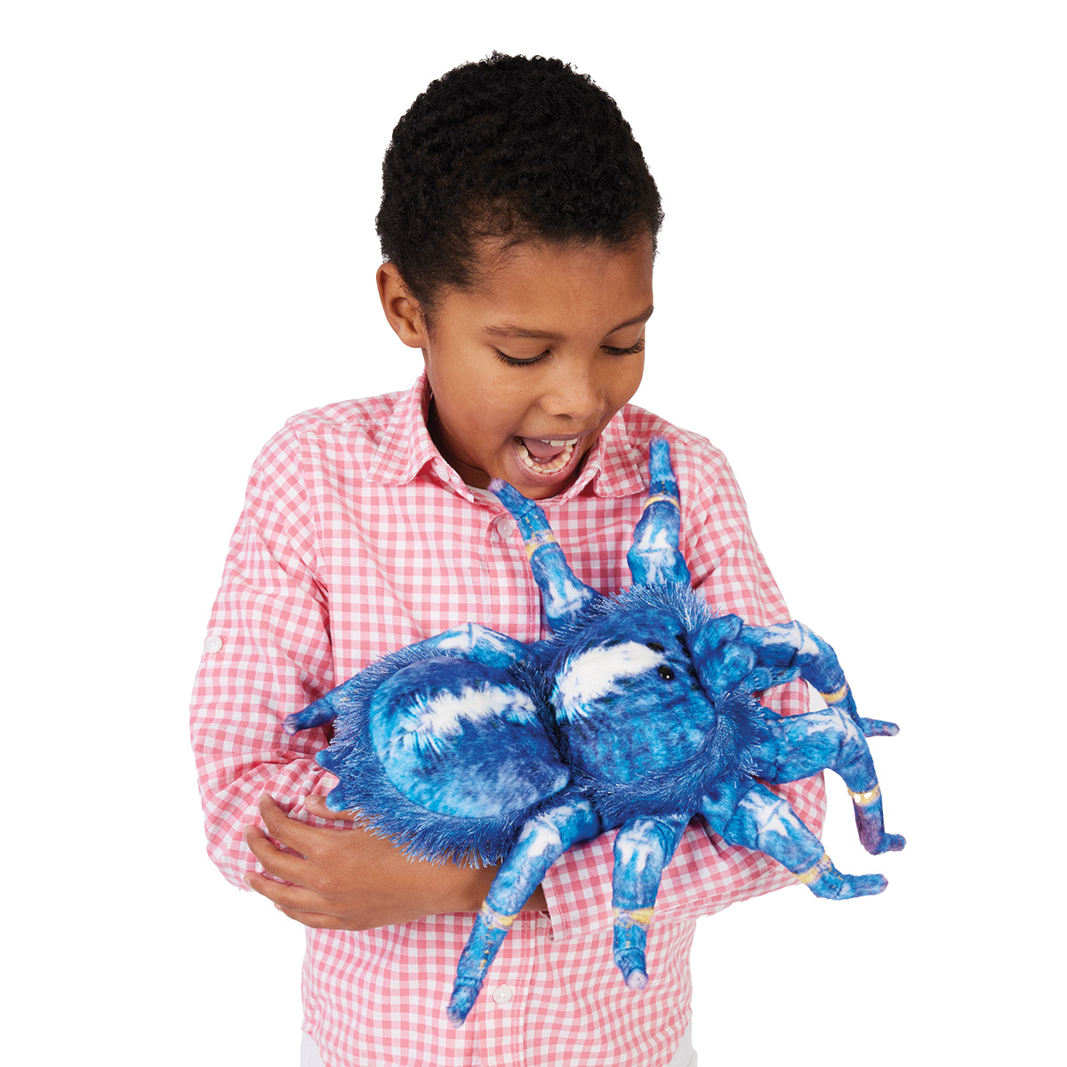 Kind hält Folkmanis Handpuppe Blaue Ornament-Vogelspinne mit blau-weißem Plüschkörper und acht Beinen lachend in den Händen.