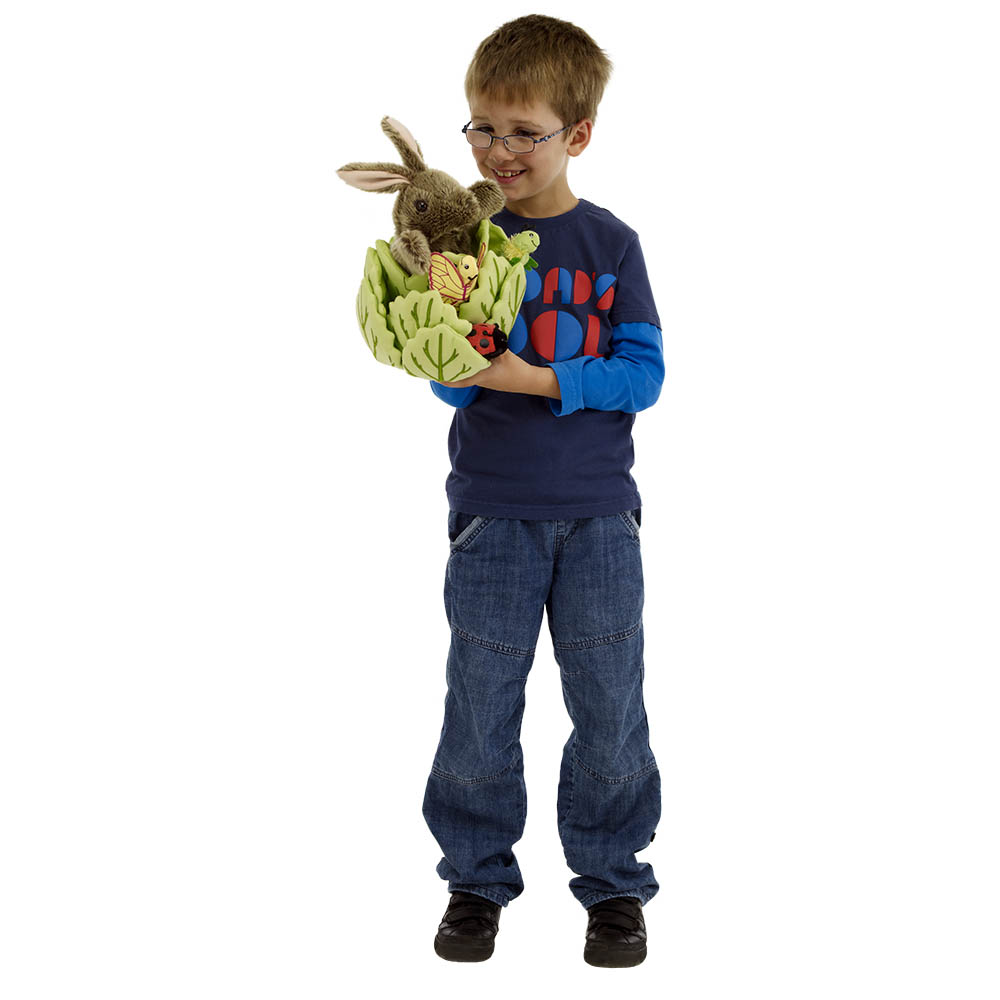 Junge im blauen Pullover hält die The Puppet Company Handpuppe Kaninchen im Kopfsalat auf dem Arm