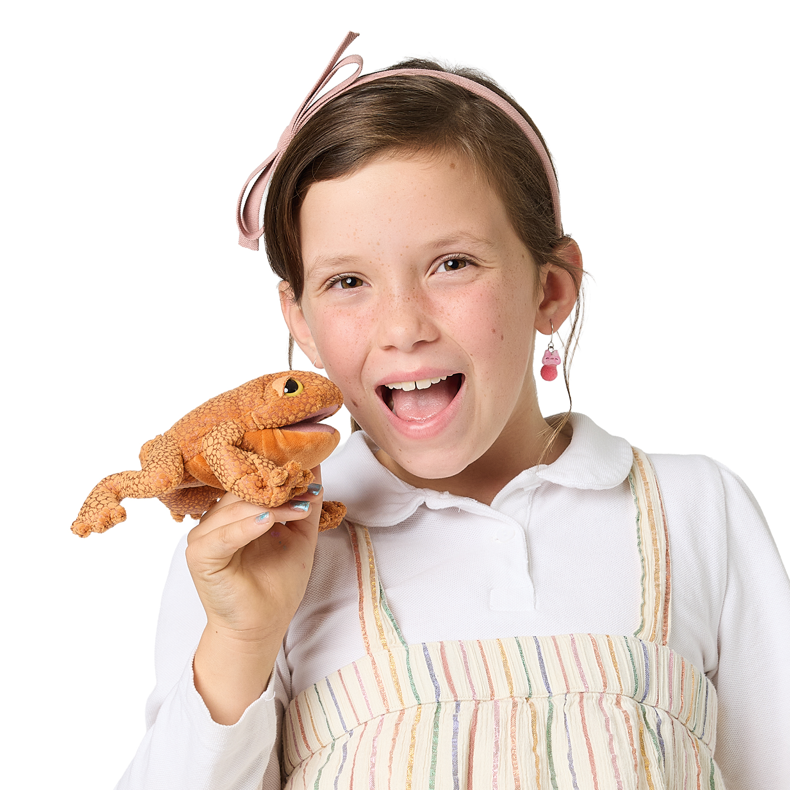 Girl laughing at the camera while holding a Folkmanis mini toad finger puppet in orange-brown with a textured surface
