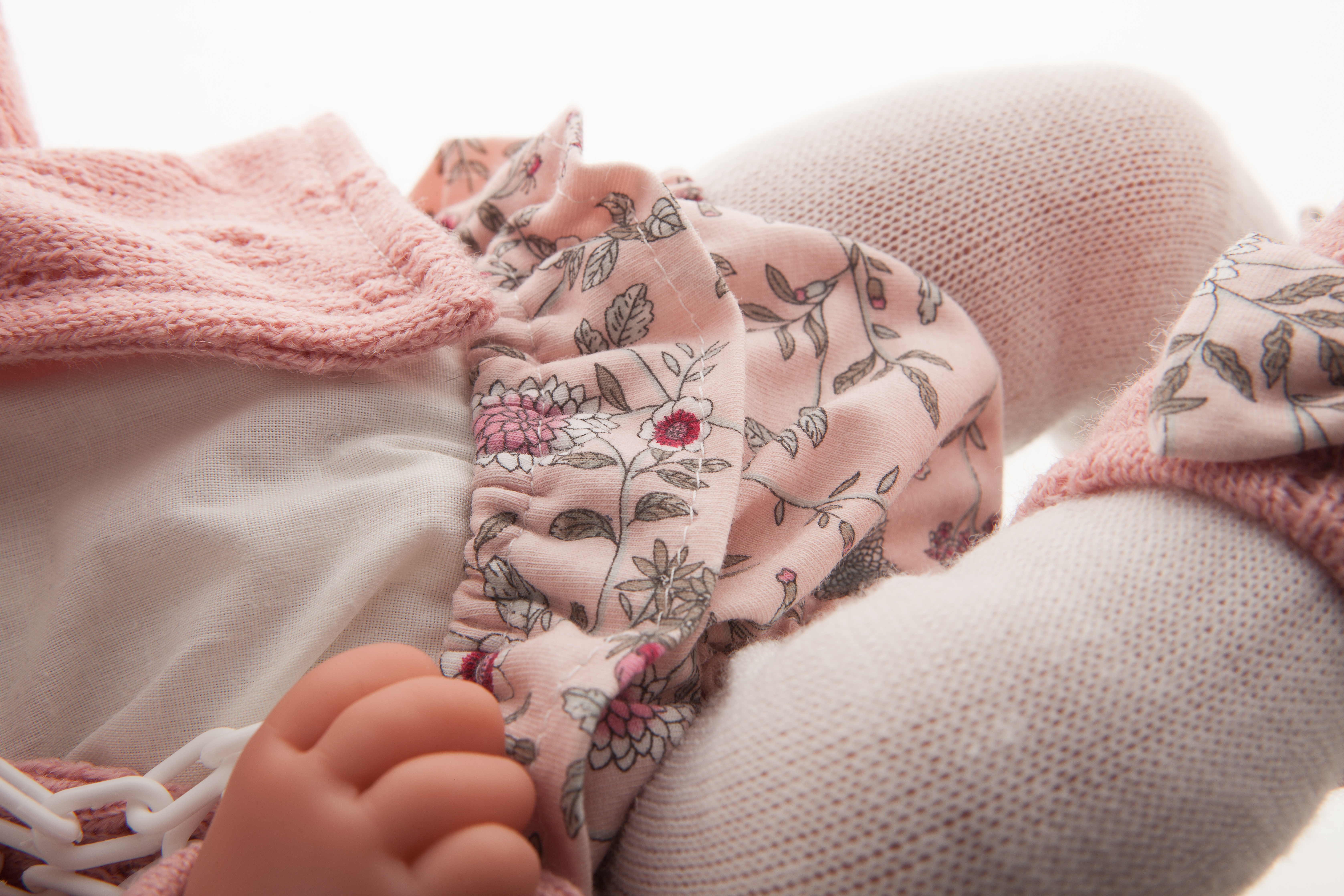 Antonio Juan Babypuppe Pipa, Detailaufnahme der Blumenmuster-Höschen mit Hand und rosa Strickärmel