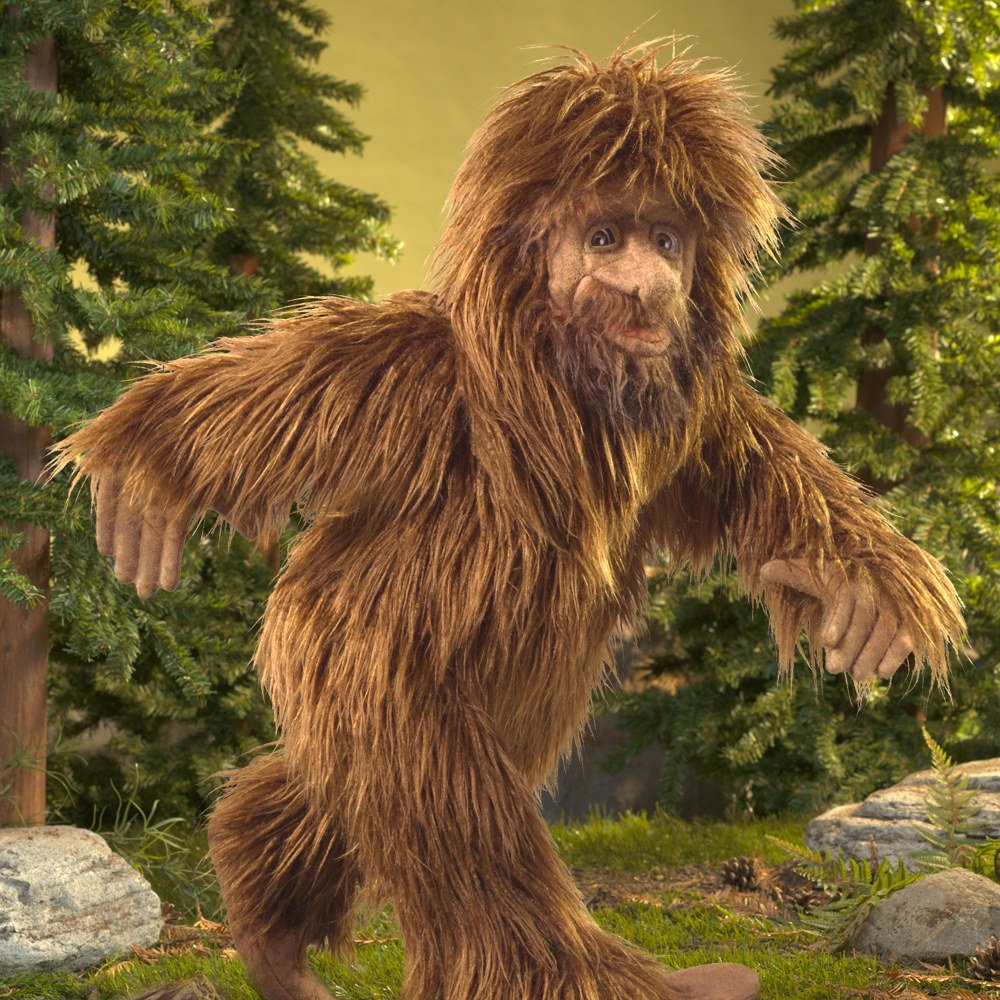 Folkmanis Handpuppe Bigfoot mit zottigem braunem Fell, ausgebreiteten Armen und detailliertem Gesicht, vor Waldkulisse