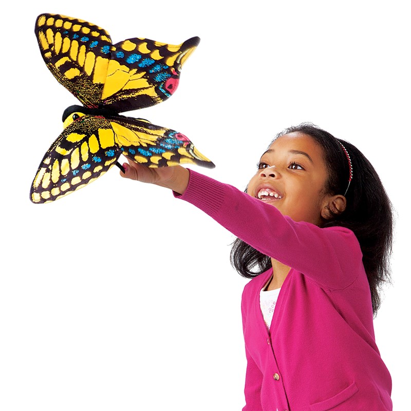 Mädchen hält Folkmanis Schwalbenschwanz Schmetterling Handpuppe mit gelb-schwarzen Flügeln in die Höhe