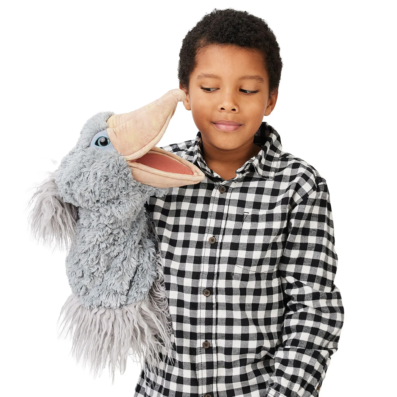 Boy holding up a grey Folkmanis shoebill hand puppet with an open beak and blue eyes