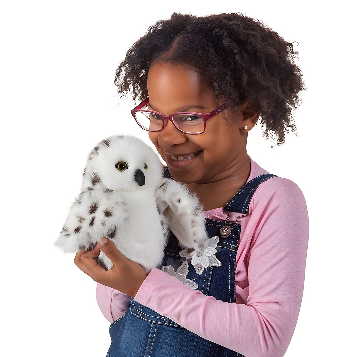 Mädchen hält Folkmanis Handpuppe kleine Schneeeule mit weißem Gefieder und dunklen Flecken in den Händen