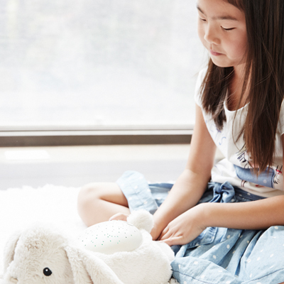 Cloud b sleep aid Twilight Buddies rabbit, lifestyle photo with girl holding the plush toy